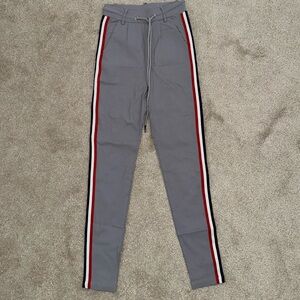 High waisted grey pants with red, blue and white stripes on the side